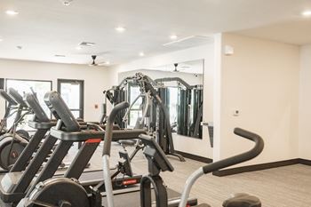 a gym with elliptical machines and a mirror
